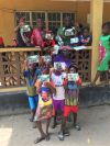 <p>Einige Kinder und Herr Bangura präsentieren ihre Fotogeschenke</p>